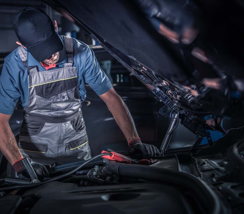 Mechanic repairing a car under the hood in the service bay